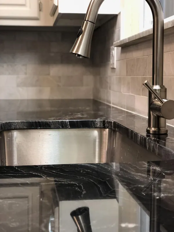 Black granite sink area with a pull-down faucet