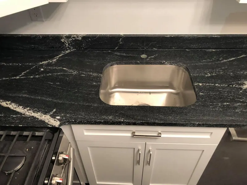 Black granite with white veining around an undermount sink