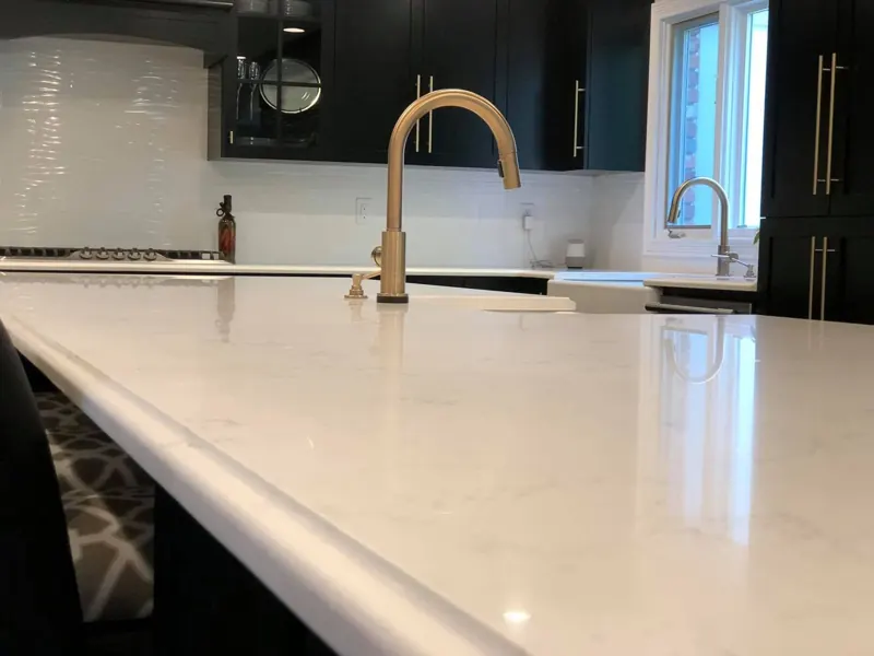 White quartz countertop with a brass faucet
